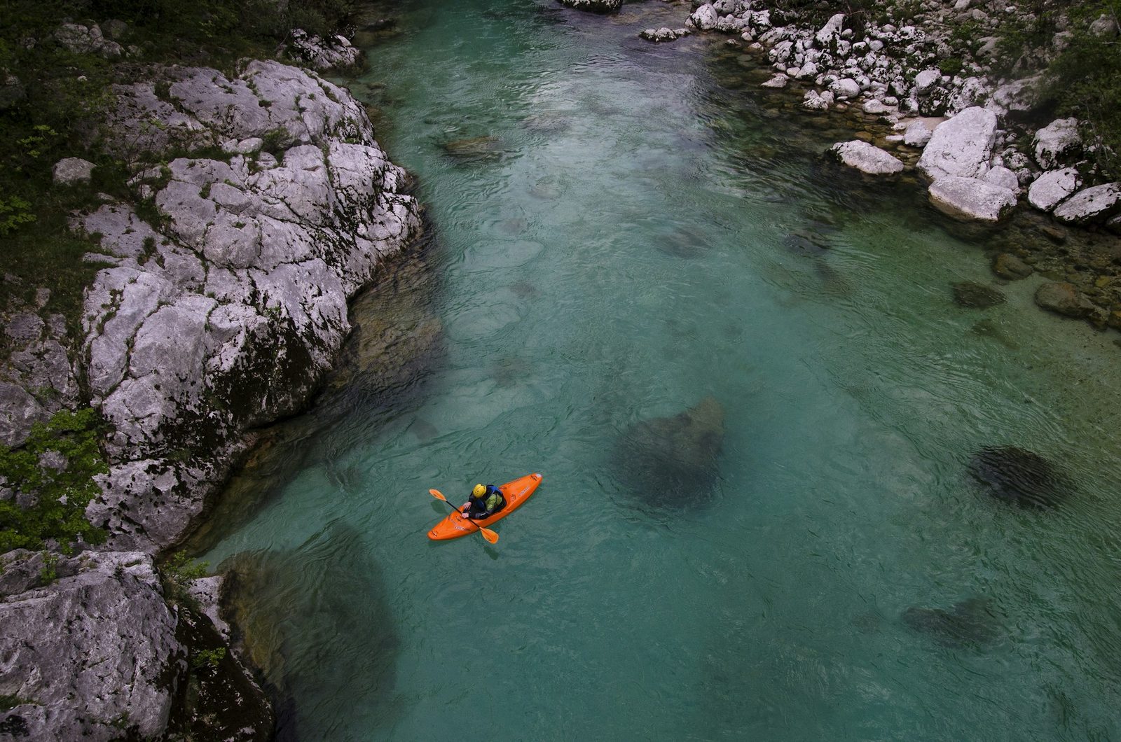 Un kayak sur une rivière turquoise, entre les rochers