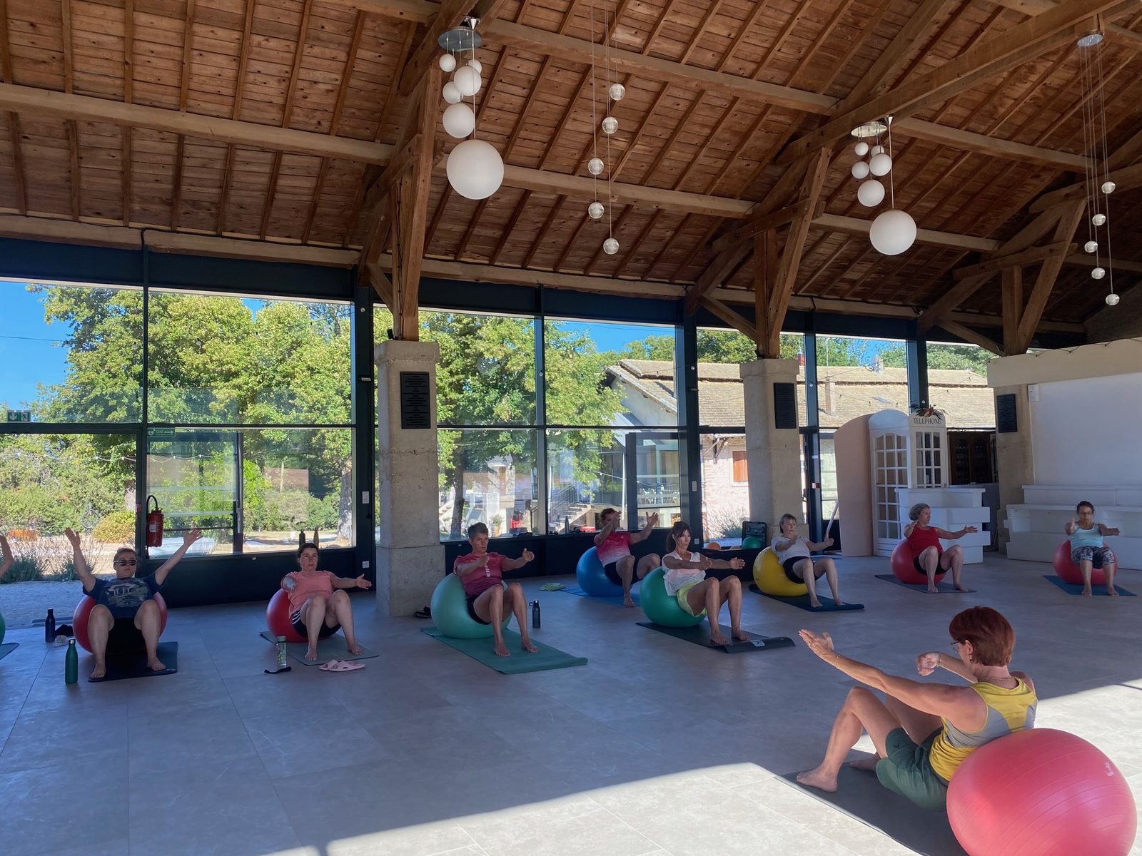 Un cours de pilates sur ballons dans la salle, baies ouvertes